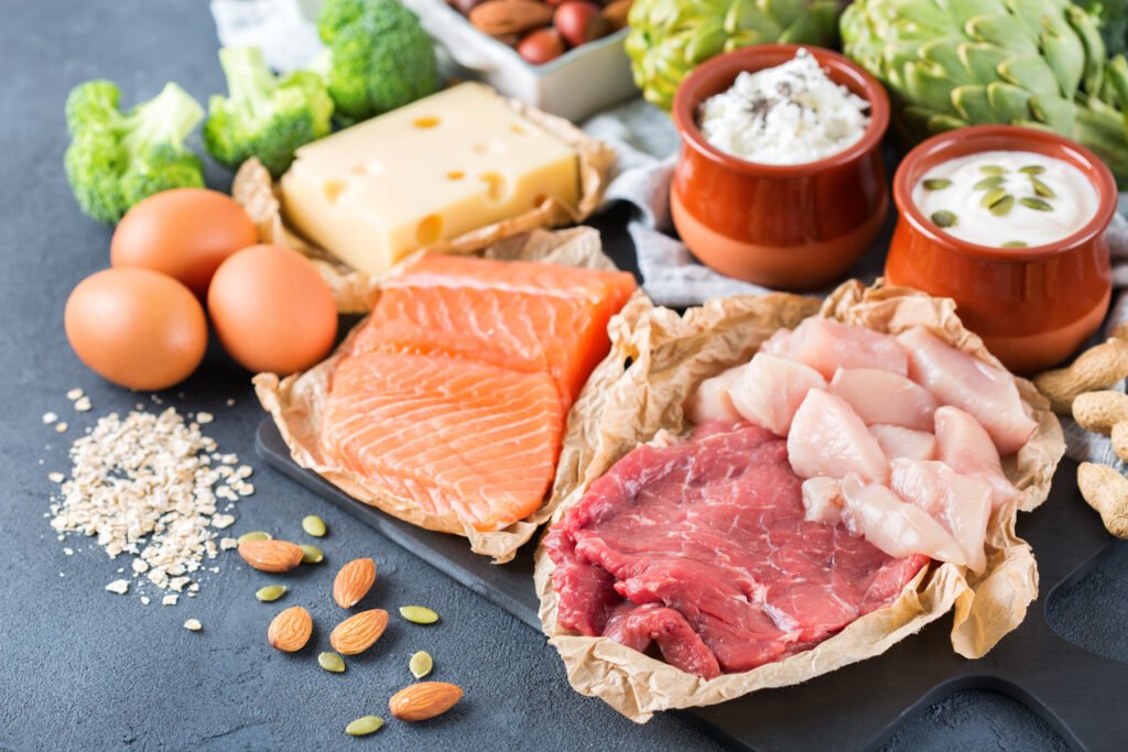 Assortment of healthy protein source and body building food. Meat beef salmon chicken breast eggs dairy products cheese yogurt beans artichokes broccoli nuts oat meal