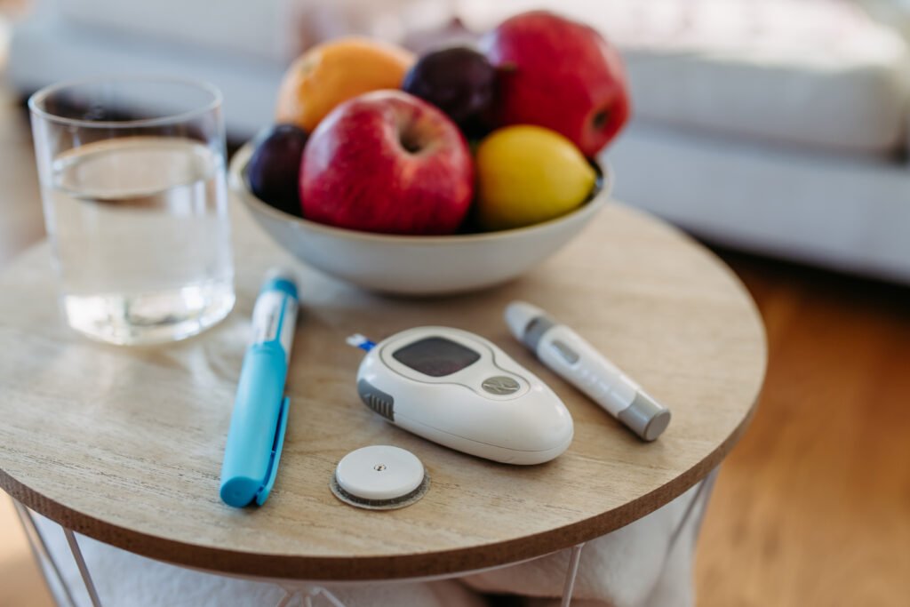 Close up of desserts for diabetes supplies and devices on table. Continuous glucose monitor, insulin pen, blood glucose meter. Image with copy space.