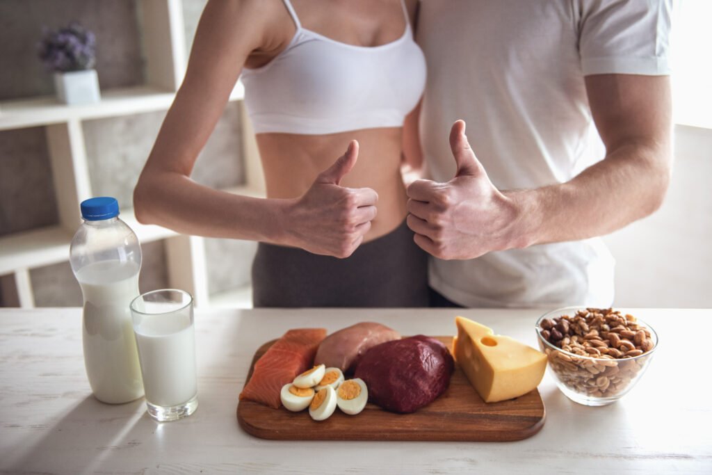 Cropped image of beautiful young sports couple cooking healthy food in kitchen at home