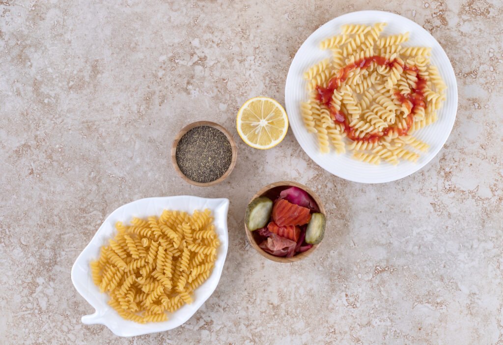 Simple Carbohydrates and portions of pasta with appetizer and seasoning on marble background