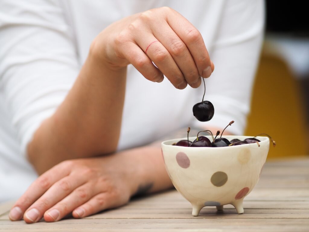 Diabetic woman holding bowl of fresh picked sweet cherries 