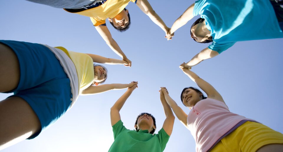 A group of young Chinese people in a circle showing simble of social health,