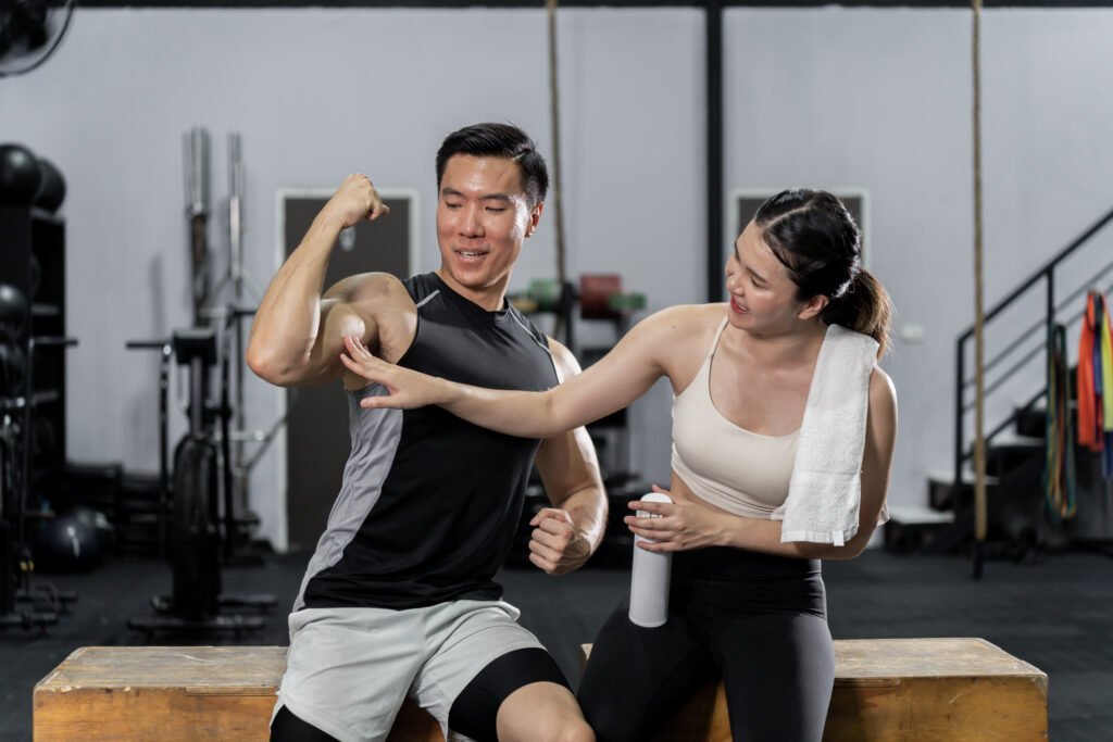 Asian men and women Have a strong body, good health, love to exercise. They are exercising together at the gym having fun.