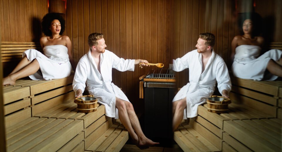 Beautiful young couple sitting together in a sauna spa