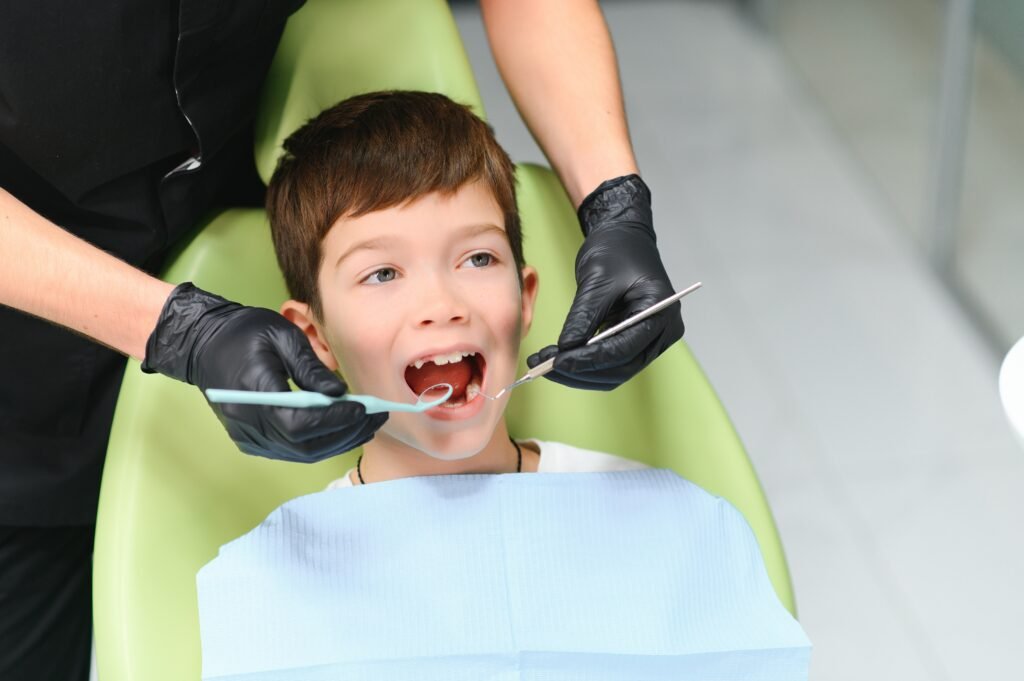 Close-up of little boy opening his mouth during dental checkup.