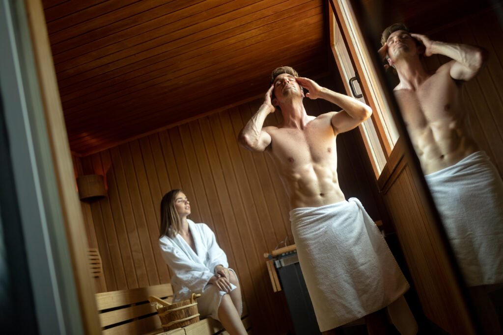 Young couple enjoying finnish sauna during their spa weekend