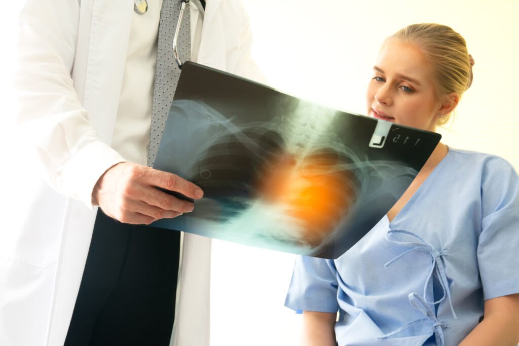 Doctor explaining lungs x-ray to women patient in clinic or Doctor in the office examining an x-ray and discussing with a patient about shortness of breath.