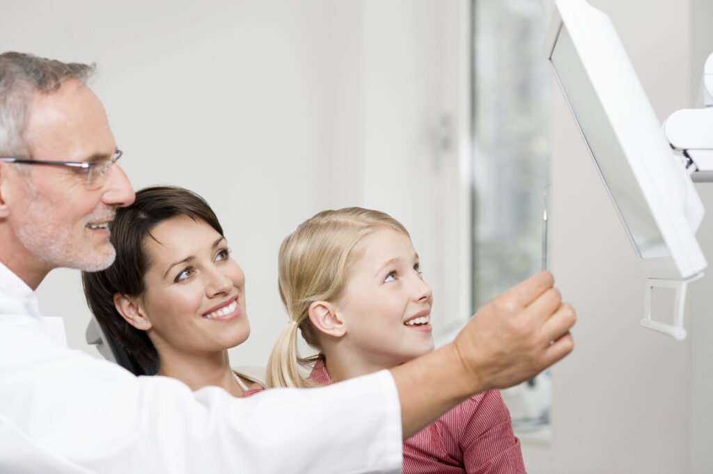 Family happily looking at a screen together to see dental health.