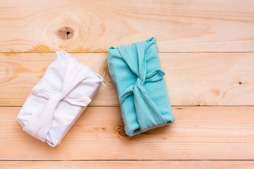 Furoshiki eco-friendly gifts wrapped in cloth on a wooden background. Zero waste. Top view