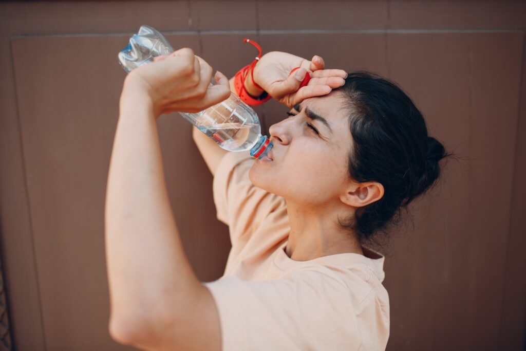 indian woman drinking water to save itself from dehydration.