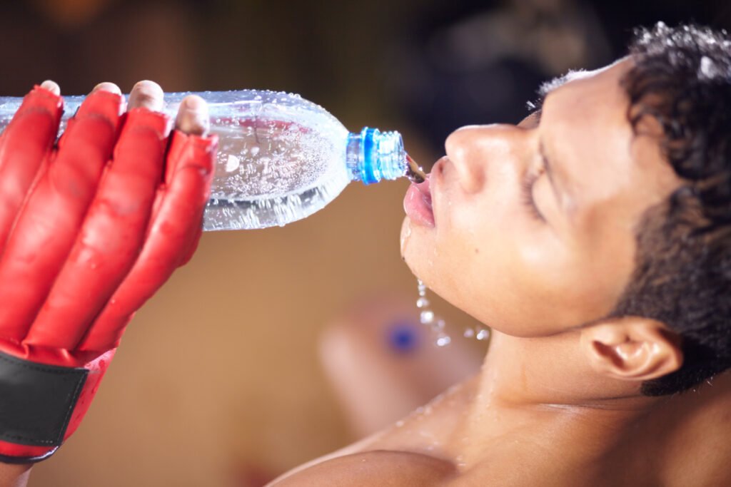 Keeping himself hydrated. A high angle view of a young fighter drinking from a bottle of water