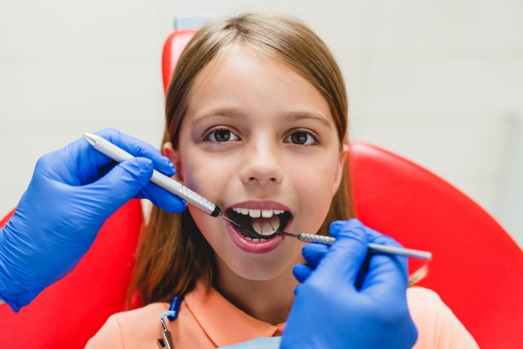 A little small kid girl preteen taking care of her teeth having toothache, while male dentist orthodontist examining whitening dental cavity. Stomatology medicine concept