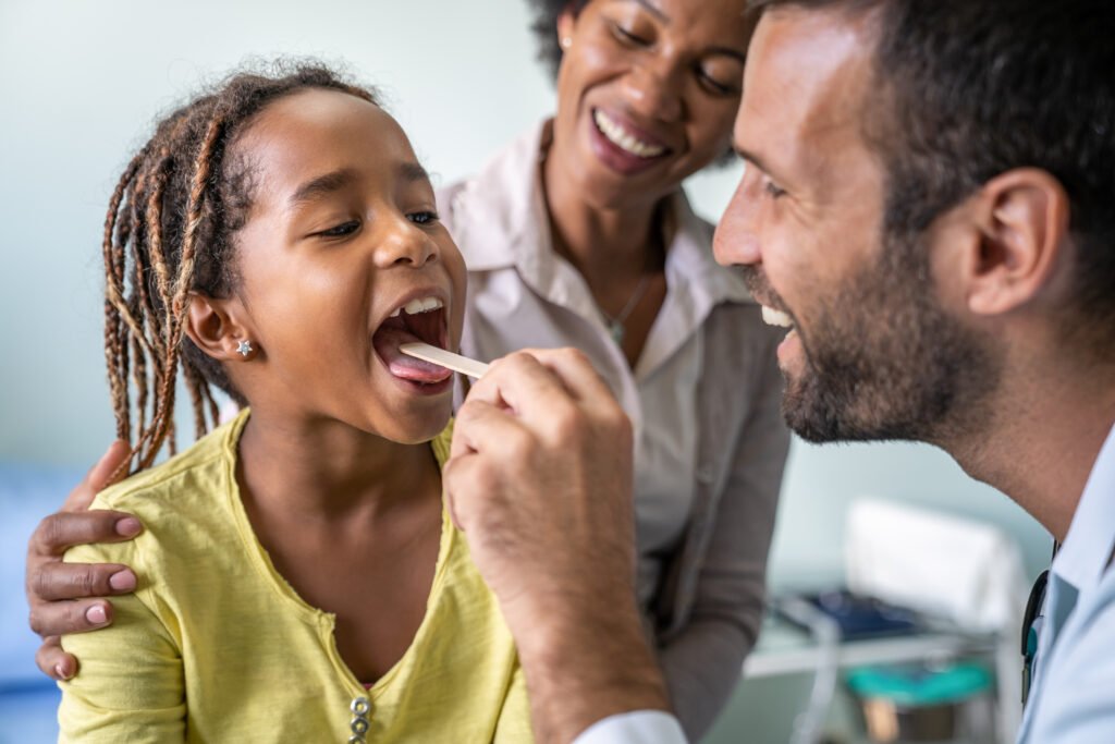 Pediatrician examining little girl's dental with tongue health. Healthcare prevention child concept