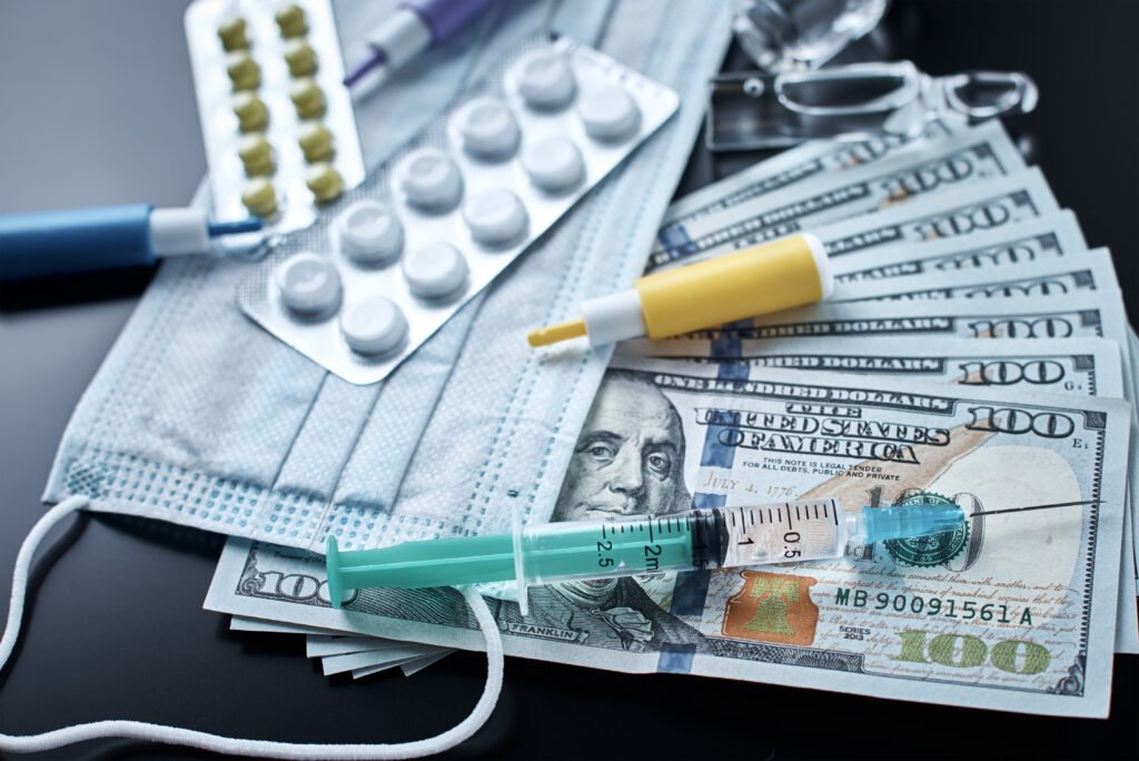 Tablets, protective mask, medical items and dollar bills on dark background. Expensive medicine concept. Pharmaceutical industry and medical insurance