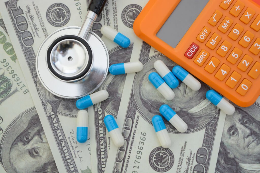 Stethoscope, pill capsules, money and calculator. Save money on health care insurance, drug cost and medical cost concepts