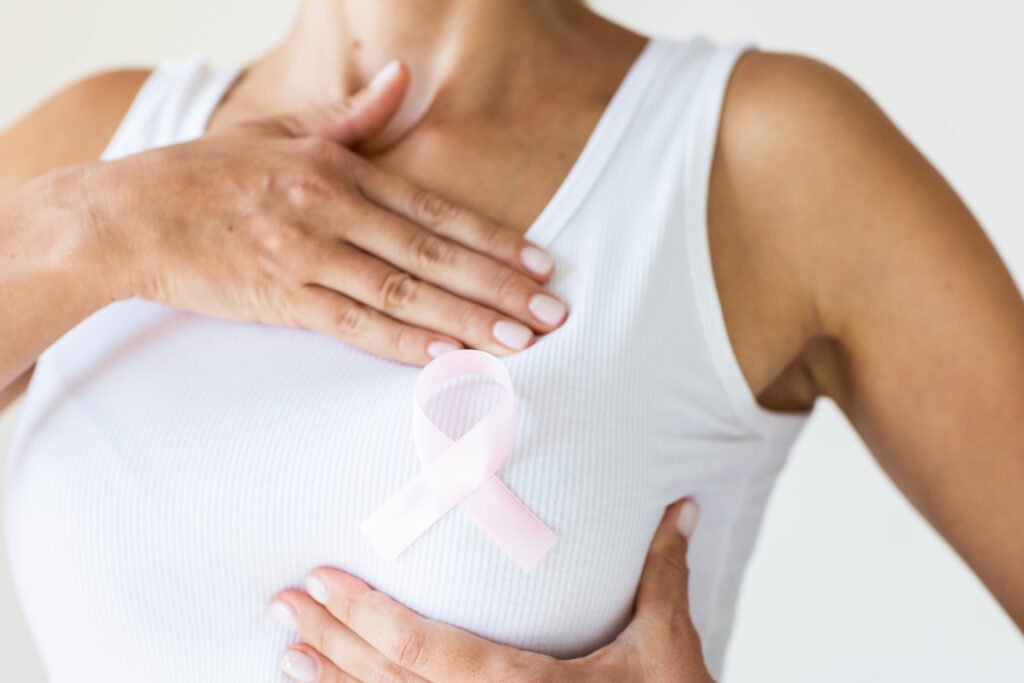 Woman with pink ribbon symbol of breast cancer awareness month. High quality photo